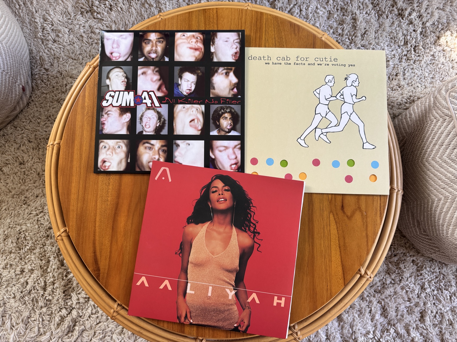 3 vinyl records being displayed on a coffee table